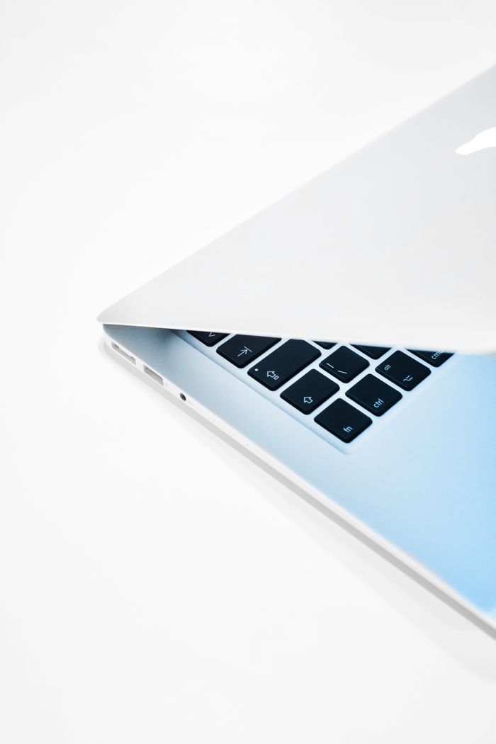 gallery-3 Close-up of a sleek laptop slightly opened on a crisp white background.