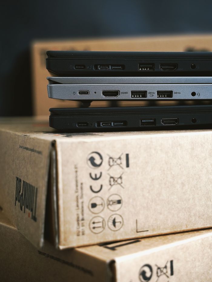 ours-journey Close-up of stacked modern laptops on cardboard boxes emphasizing portable technology.