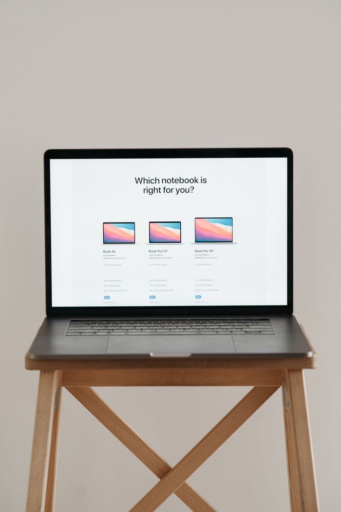gallery-1 Laptop on a wooden stand with screen showing notebook comparison.