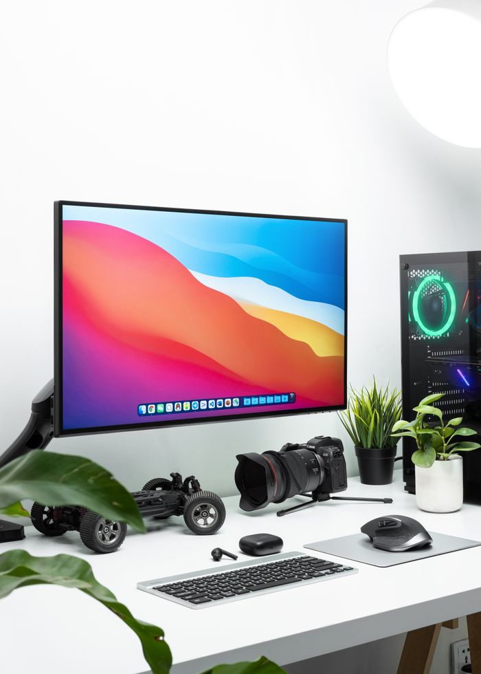 about-01 Clean and contemporary desk setup featuring a monitor, camera, and tech gadgets in a modern workspace.